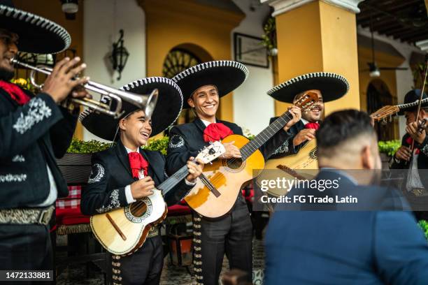 mariachi band playing at a restaurant outdoors - mexican embroidery stock pictures, royalty-free photos & images