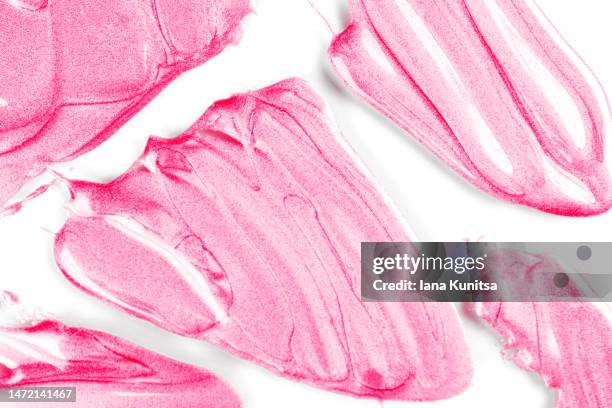 pink lipstick smears on white background, isolated. lip gloss samples are smudged. beauty cosmetic pattern. makeup and skin care products. - pink lips fotografías e imágenes de stock