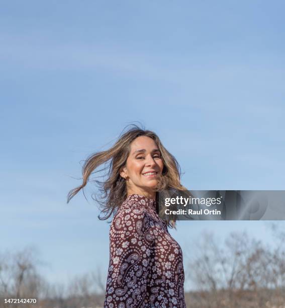 happy woman with tousled hair blowing on air - face wind stock pictures, royalty-free photos & images