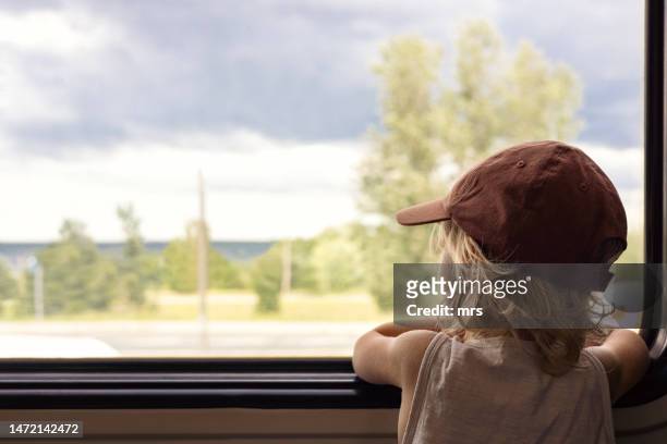 little boy looking out of train window - bambino treno foto e immagini stock