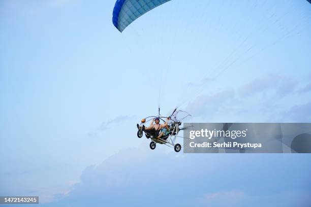 flying on a powered hang glider - motor paraglider stock pictures, royalty-free photos & images