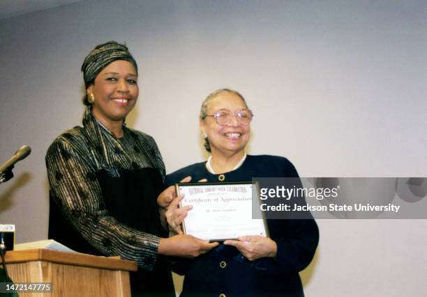 Dr. Lou Helen Sanders giving certificate to Doris E. Saunders during National Library Week Celebration.