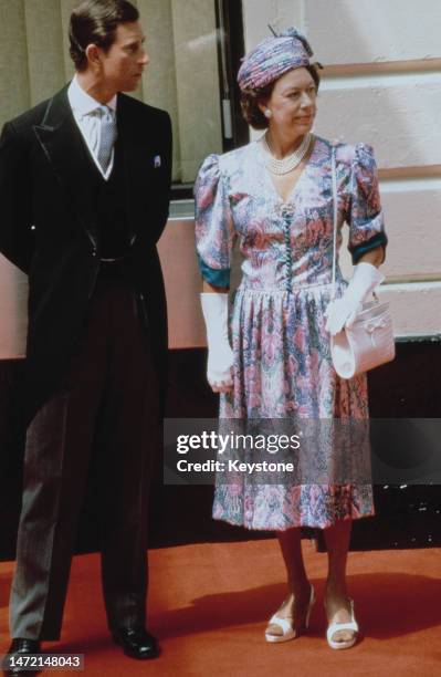 British Royals Charles, Prince of Wales, and his aunt, Princess Margaret, Countess of Snowdon, wearing a floral pattern outfit with a matching hat...