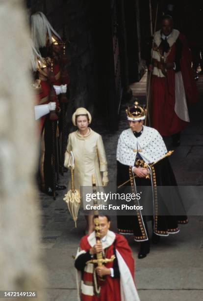 British Royals Elizabeth II and her son, Charles, Prince of Wales, wearing a gold coronet and a ceremonial robe trimmed with ermine, during the...