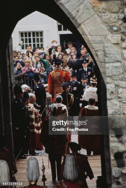 Rear view of British Royals Prince Philip, Duke of Edinburgh, and his son, Charles, Prince of Wales, wearing a gold coronet and a ceremonial robe...