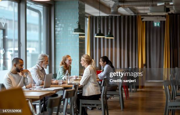 business people having a meeting in a restaurant - internet cafe stockfoto's en -beelden