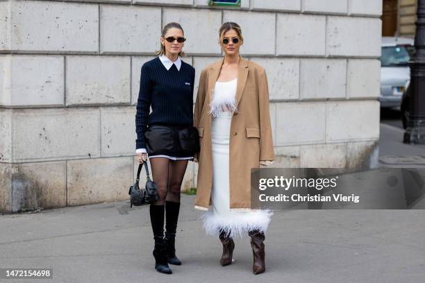 Helena Bordon wears navy knit white blouse, black mini skirt, tights, bag, mid high heeled boots & Lala Rudge wears beige coat, white cropped top...