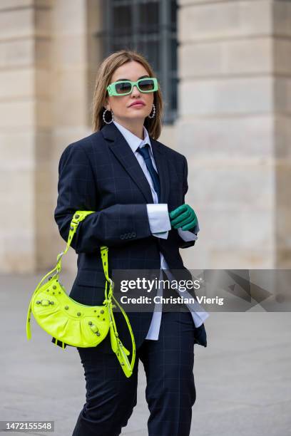 Caroline Ogliaro wears black jacket trousers tie shirt Mango Man, green sunglasses Gucci, earrings APM Monaco, neon bag Balenciaga, shoes Jimmy Choo...