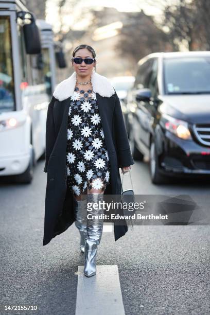 Miki Cheung wears silver hair clips, navy blue sunglasses from Prada, a diamonds necklace, a navy blue and white cut-out flower pattern knees dress,...