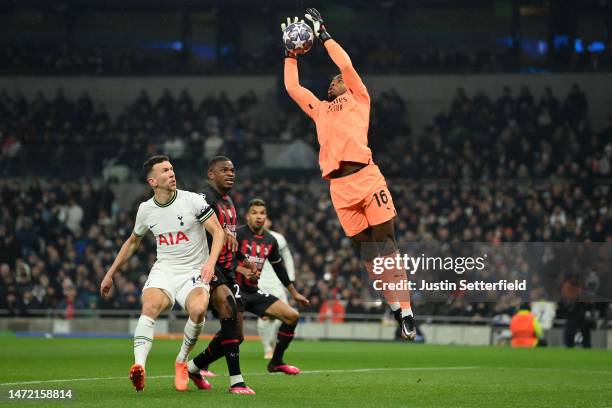 Mike Maignan of AC Milan makes a save as Ivan Perisic of Tottenham Hotspur looks on during the UEFA Champions League round of 16 leg two match...