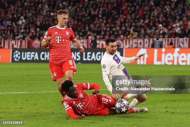 Lionel Messi of Paris Saint-Germain is tackled by Alphonso Davies of FC Bayern Munich during the UEFA Champions League round of 16 leg two match...