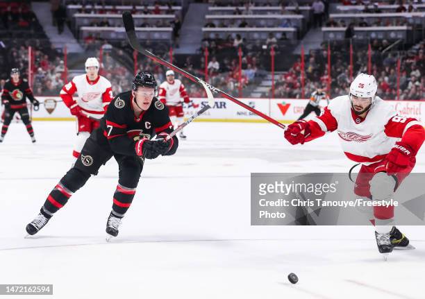 Brady Tkachuk of the Ottawa Senators battles for the puck with Jake Walman of the Detroit Red Wings at Canadian Tire Centre on February 28, 2023 in...