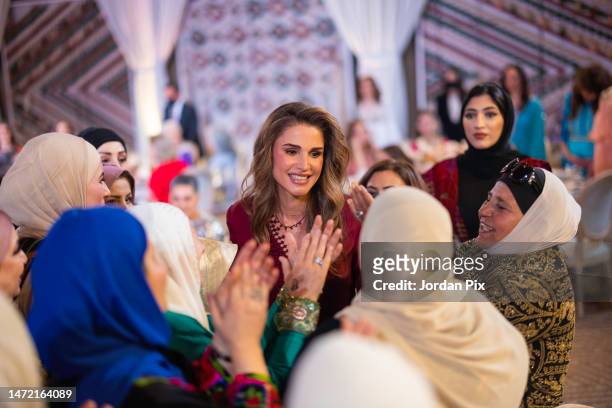 In this handout photo issued by The Royal Hashemite Court, Her Majesty Queen Rania with Jordanian women attends the Henna party Her Majesty Queen...
