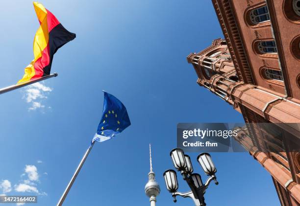 berlin town hall (rotes rathaus) and television tower with german- and eu-flags (germany) - government building stock-fotos und bilder