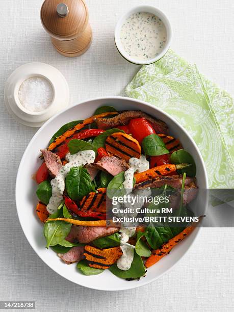 salad with sausage and peppers - dressing up stock-fotos und bilder