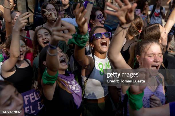 Women wearing green and purple bandanas chant during a demonstration called to commemorate International Women's Day on March 08, 2023 in Buenos...