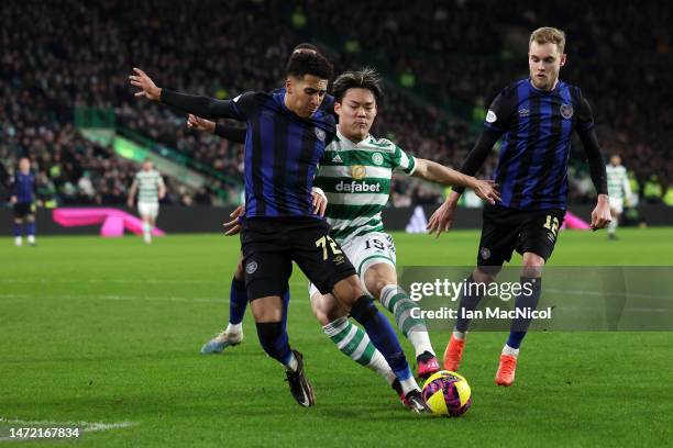 James Hill of Heart of Midlothian and Oh Hyeon-Gyu of Celtic battle for the ball during the Cinch Scottish Premiership match between Celtic FC and...