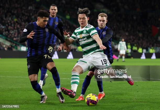 Oh Hyeon-Gyu of Celtic prepares to shoot whilst under pressure from James Hill of Heart of Midlothian during the Cinch Scottish Premiership match...