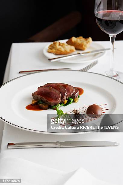 plate of beef with glass of wine - wildbret stock-fotos und bilder