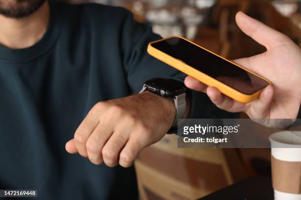 man making nfc payment with his smart watch - digital clock bildbanksfoton och bilder