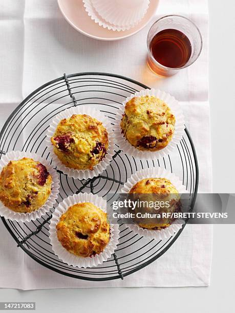fruit muffins on cooling rack - muffin stockfoto's en -beelden
