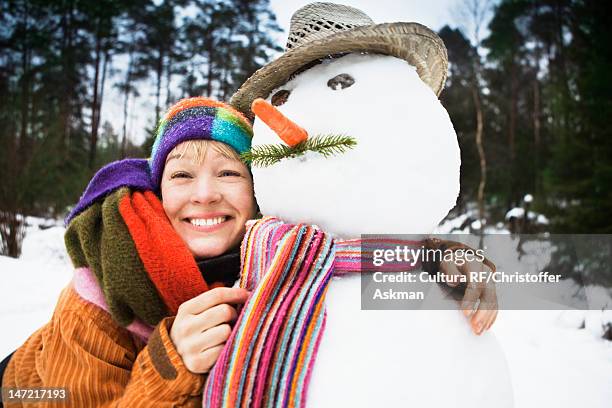smiling woman hugging snowman - sverige vinter bildbanksfoton och bilder