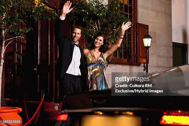 formal couple waving down taxi - leaving restaurant stock pictures, royalty-free photos & images