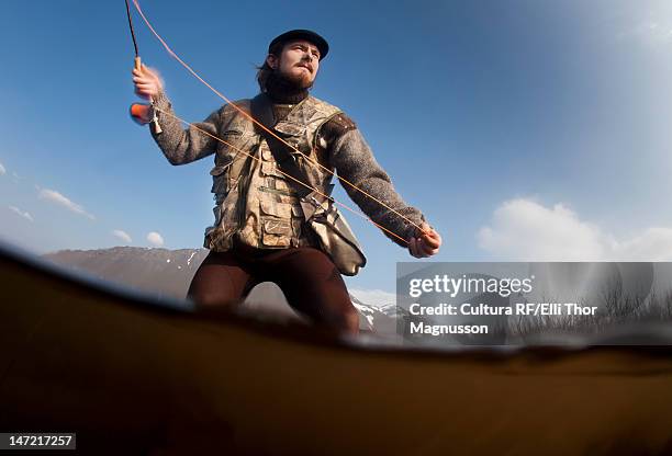 low angle view of man fishing in lake - angel island stock-fotos und bilder