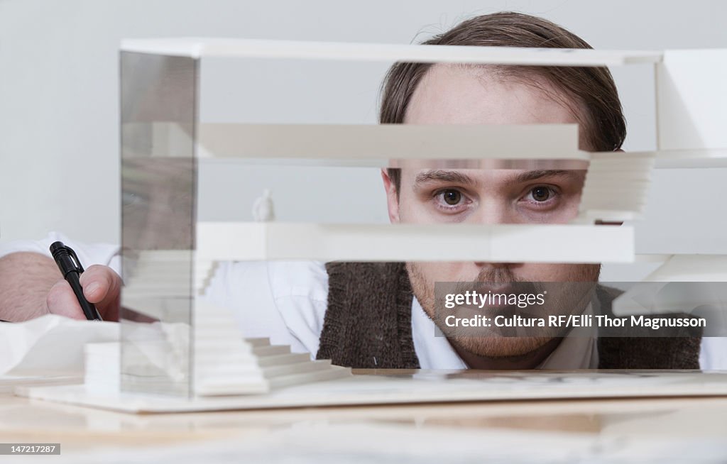 Businessman looking through model