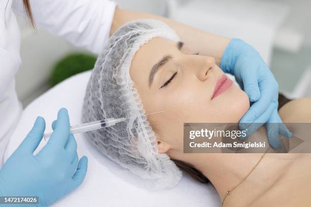 relaxed patient receiving skin treatment with a cannula in the beauty salon - cannula stock pictures, royalty-free photos & images