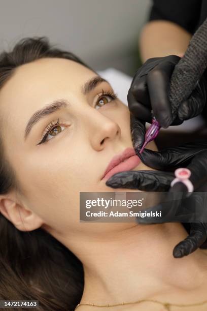 permanent lip make-up application by a make-up artist in a beauty salon - lip tattooing stock pictures, royalty-free photos & images