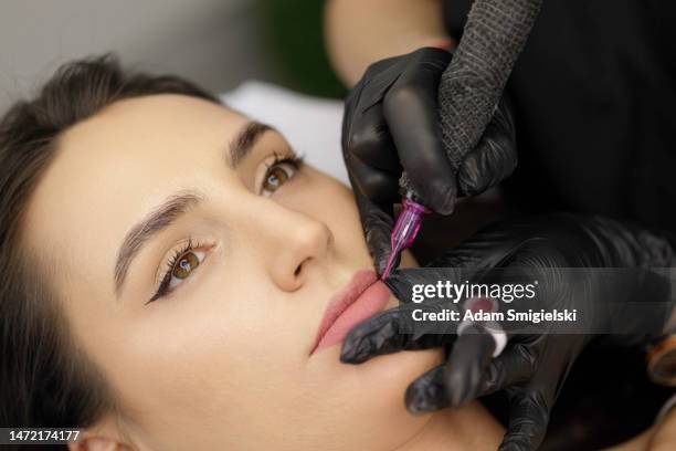 permanent lip make-up application by a make-up artist in a beauty salon - lip tattooing stock pictures, royalty-free photos & images