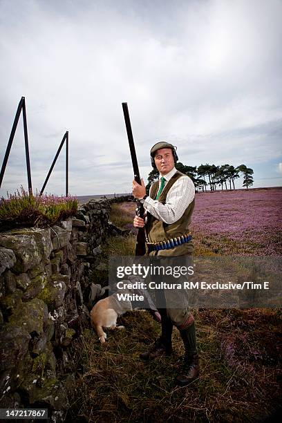 man with hunting rifle and dog - vogeljagd stock-fotos und bilder