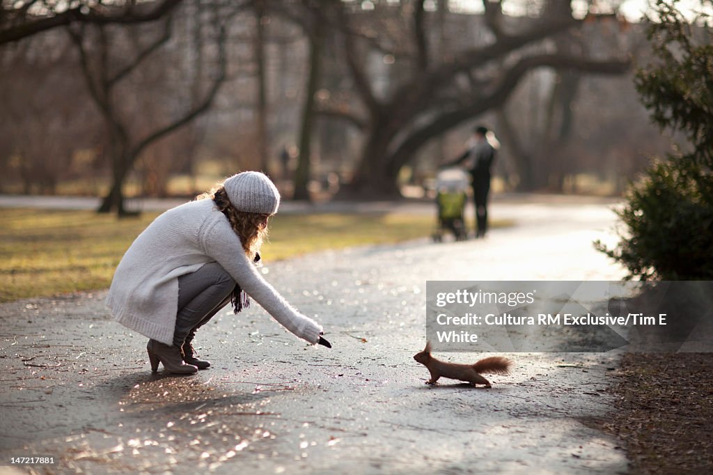 Woman feeding squirrel in park