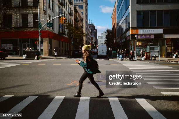 pendolare che mangia una fetta di pizza in movimento a new york - attraversare foto e immagini stock