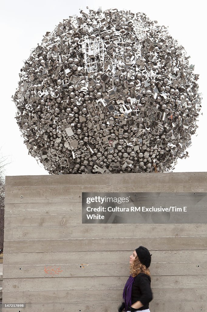 Woman walking under metal sculpture