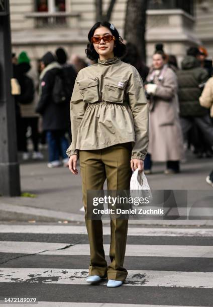 Proud Oranicha Krinchai is seen wearing a tan Miu Miu jacket, green Miu Miu pants, light blue shoes, white Miu Miu bag and brown and gold Miu Miu...