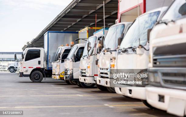 貨物を配達する準備ができている物流倉庫に駐車されたトラック - 流通倉庫 ストックフォトと画像