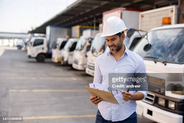 happy woman working as a supervisor at a distribution warehouse - global transportation stock pictures, royalty-free photos & images