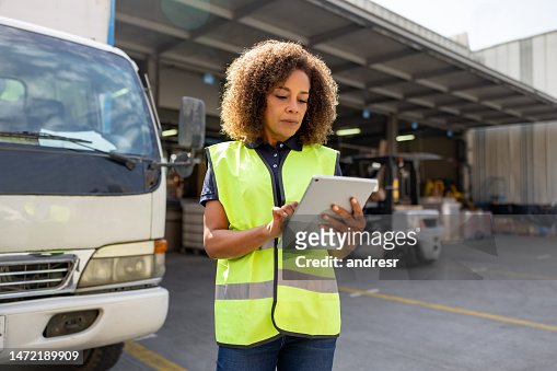 Woman supervising the dispatch of trucks at a distribution warehouse