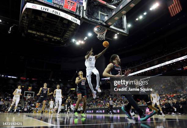 Kedrian Johnson of the West Virginia Mountaineers scores on a fast break during the Big 12 Tournament game against the Texas Tech Red Raiders at...