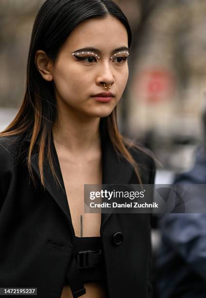 Lala Takahashi is seen wearing a black coat, black Miu Miu bralette outside the Miu Miu show during Paris Fashion Week F/W 2023 on March 07, 2023 in...