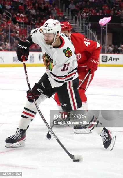 Jason Dickinson of the Chicago Blackhawks takes a shot in front of Alex Chiasson of the Detroit Red Wings during the first period at Little Caesars...