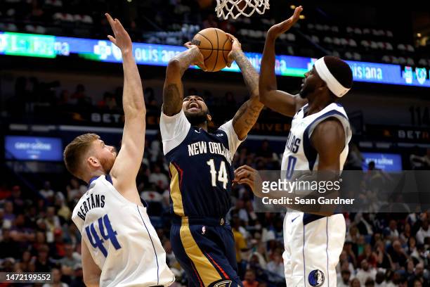 Brandon Ingram of the New Orleans Pelicans shoots over Davis Bertans and Justin Holiday of the Dallas Mavericks during the second quarter of an NBA...