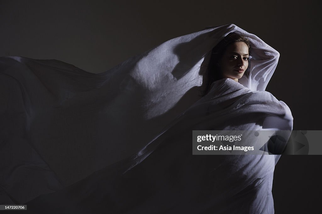 Young woman wrapped in white fabric