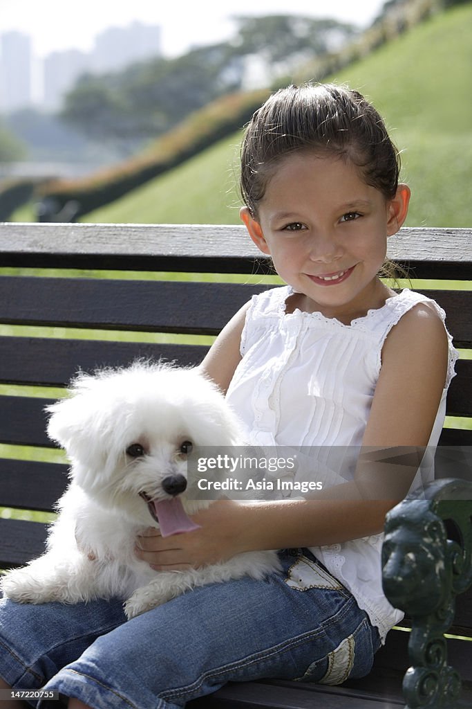 Young girl holding puppy on her lap