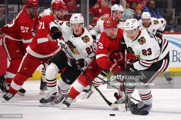 Philipp Kurashev of the Chicago Blackhawks battles for the puck against Lucas Raymond of the Detroit Red Wings during the third period at Little...