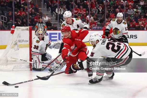 Alex Chiasson of the Detroit Red Wings battles for the puck against Jarred Tinordi of the Chicago Blackhawks during the second period at Little...