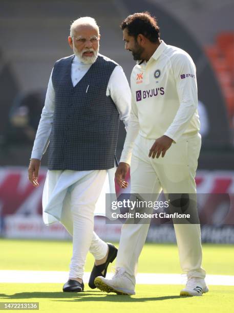 Indian Prime Minister Narendra Modi walks out with Rohit Sharma of India during day one of the Fourth Test match in the series between India and...