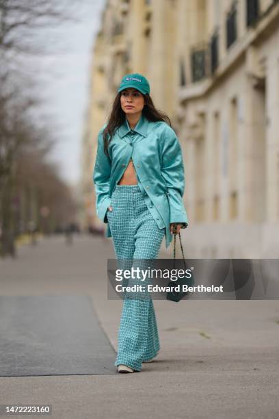 Guest wears a green denim with embroidered purple Mexicana pattern cap, a blue silk shirt from Chanel, a blue shiny silk / satin quilted pattern...